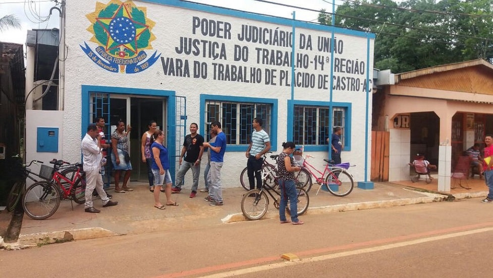 Várias pessoas em frente ao prédio antigo em que funcionava a Vara do Trabalho de Plácido de Castro, quando da sua instalação há 15 anos.