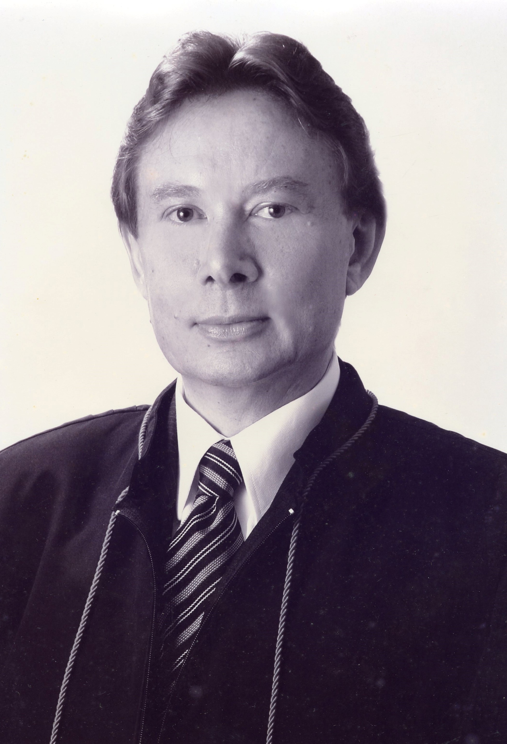 Fotografia em preto e branco, homem branco, cabelos claroso, usando toga