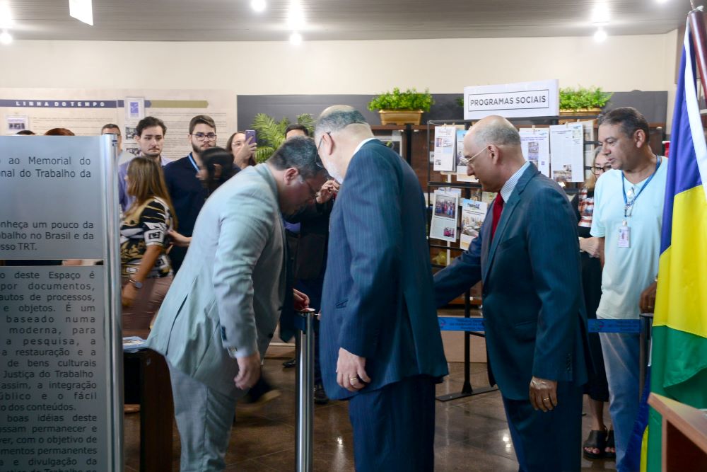 A imagem mostra os magistrados descerrando a fita de abertura da exposição.