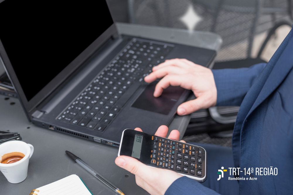 Bancário usando calculadora na mesa de trabalho